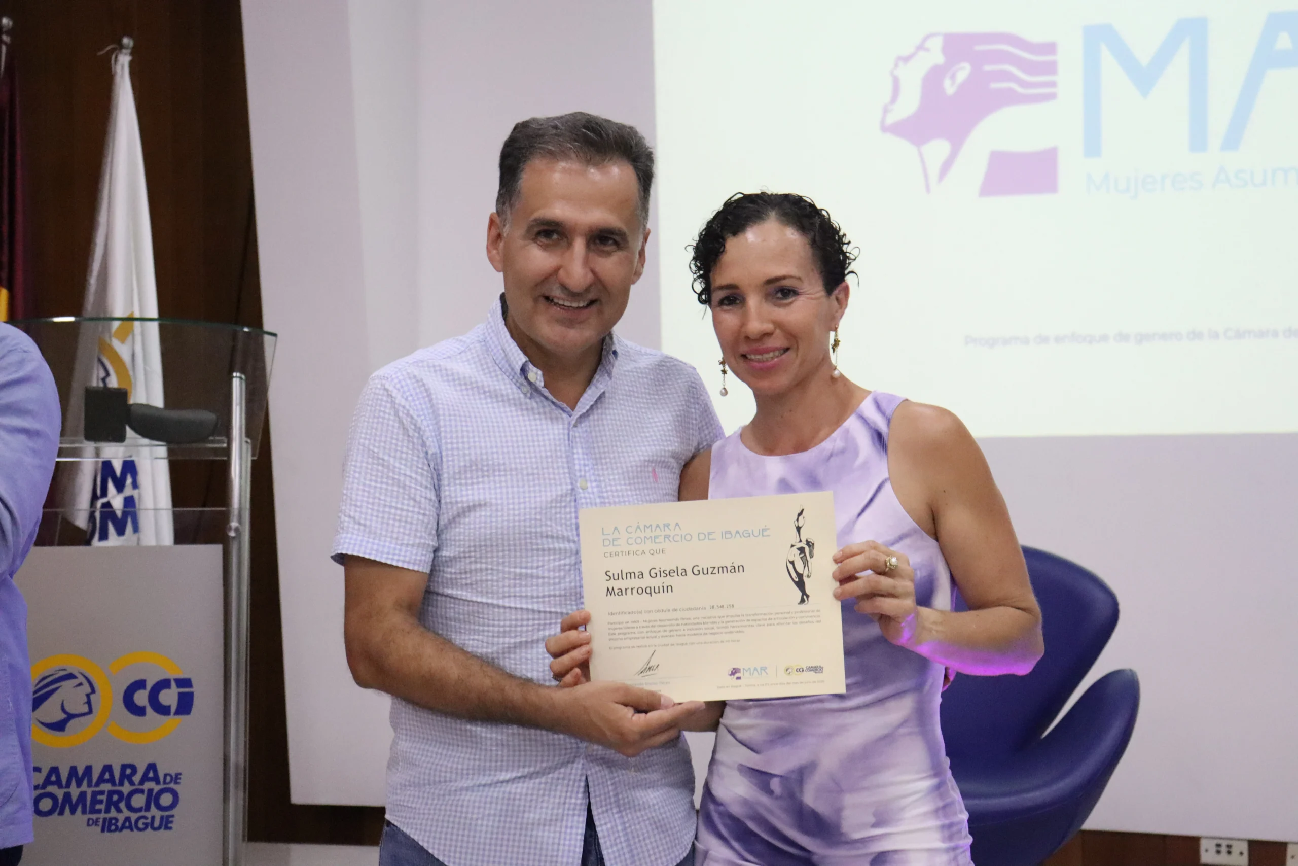 Sulma Guzmán Marroquín, recibiendo su certificación de la CCI y posando con el presidente ejecutivo de la entidad