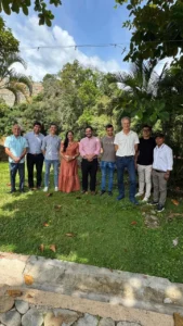 Grupo de nueve personas posando al aire libre en un espacio natural.