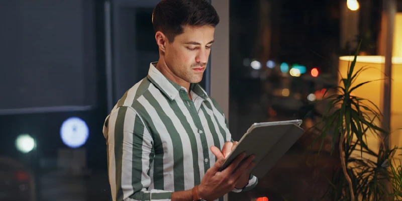 Un hombre joven observa y utiliza una tablet en un ambiente interior
