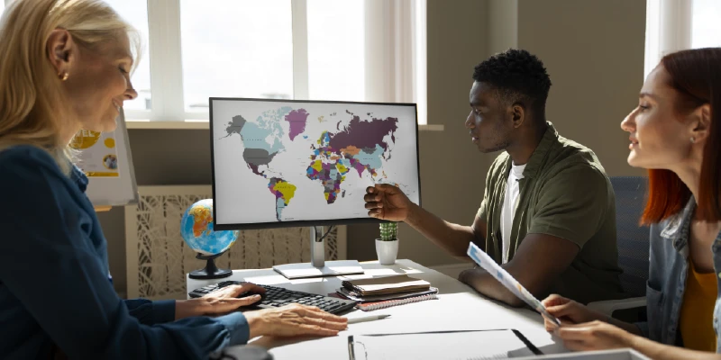 Profesionales analizan un mapa mundial en una reunión, abordando temas de proyección y contexto internacional para la toma de decisiones.