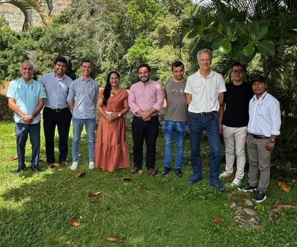 Grupo de nueve personas posando al aire libre en un espacio natural.